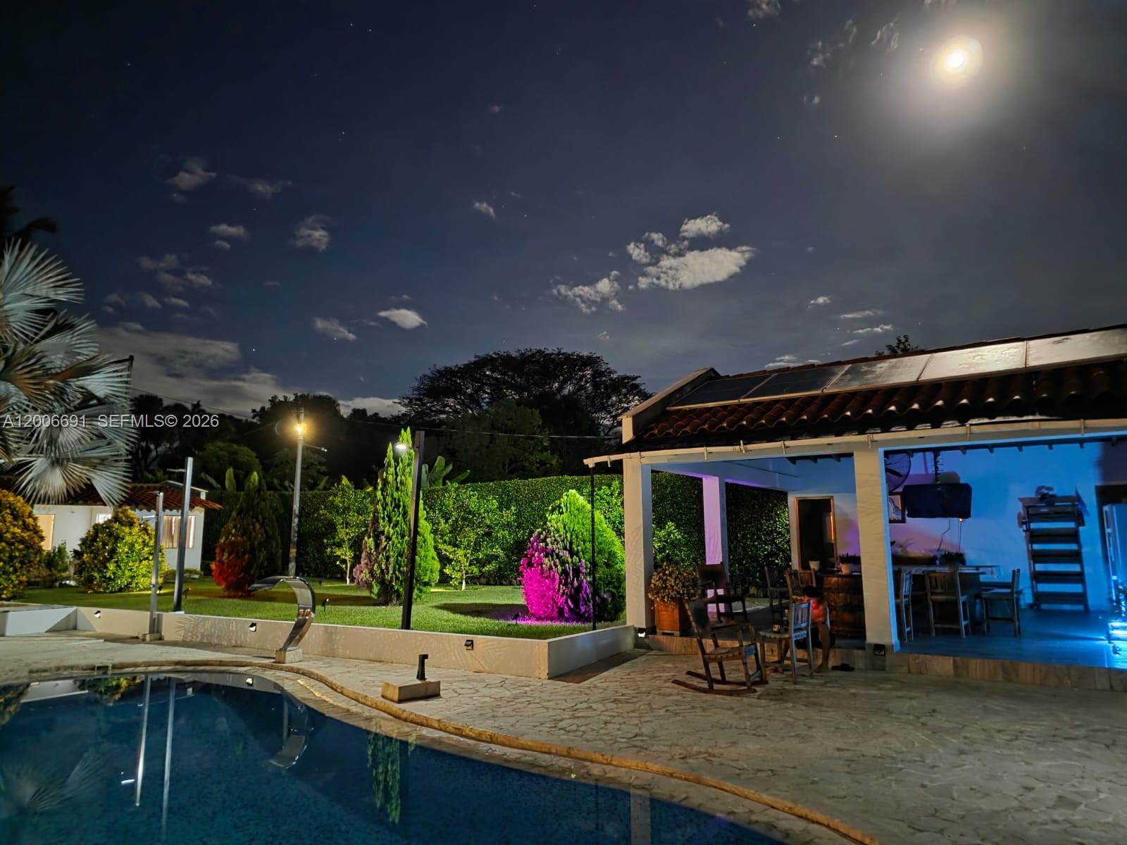A swimming pool sits in front of a patio area with a covered outdoor kitchen — Finca Villa Guadalupe Finca #175, FL 000000, FL