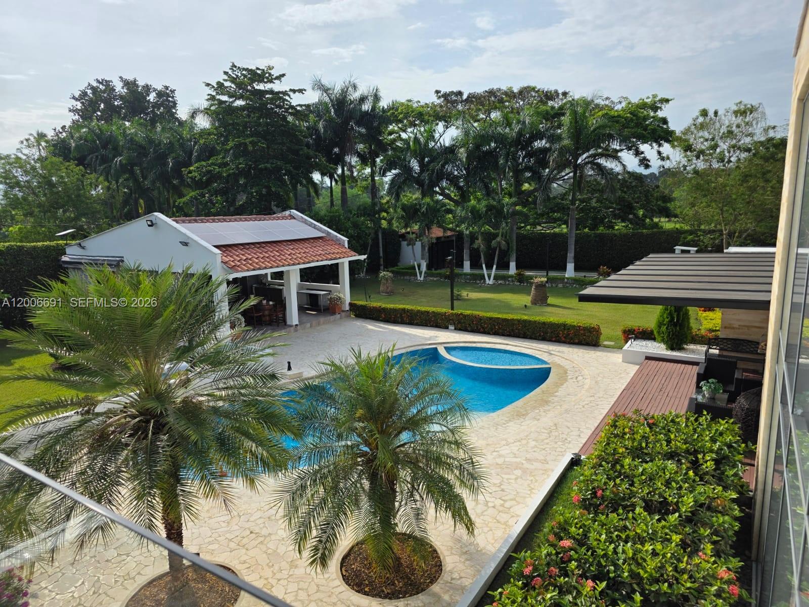 An elevated view of a backyard featuring a swimming pool, patio, and a detached structure — Finca Villa Guadalupe Finca #175, FL 000000, FL