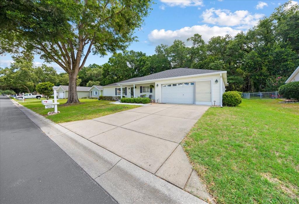 A single-story house with white siding, a two-car garage, and a concrete driveway — 14748 SW 112TH CIRCLE, DUNNELLON, FL