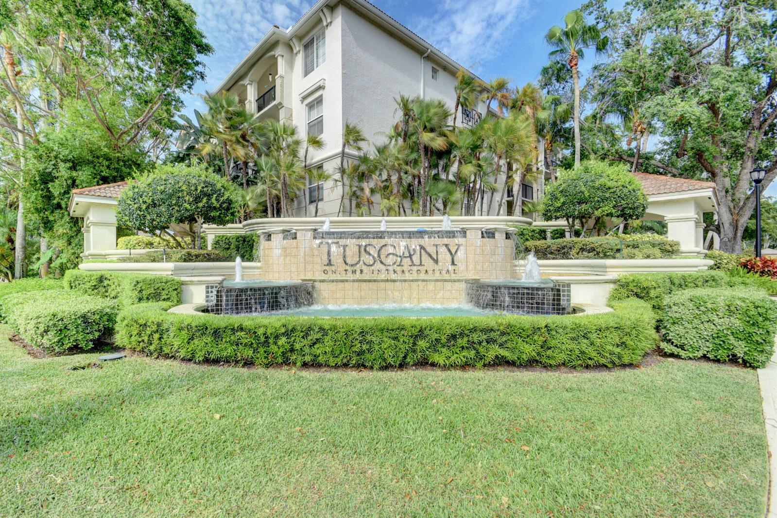 A multi-story apartment building stands behind a stone fountain with the name Tuscany displayed — 1306 Tuscany Way # 306, Boynton Beach FL 33435, BOYNTON BEACH, FL