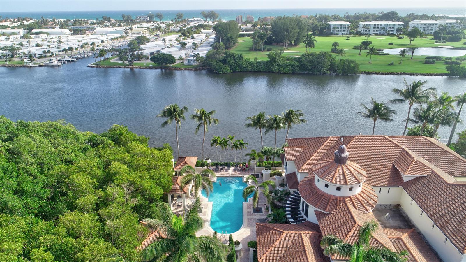 An aerial view shows a waterfront mansion with a swimming pool and a tile roof — 1306 Tuscany Way # 306, Boynton Beach FL 33435, BOYNTON BEACH, FL