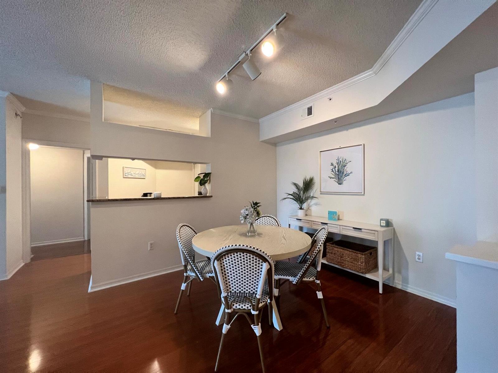 A dining area features a round table with patterned chairs, a console table, and hardwood floors — 1306 Tuscany Way # 306, Boynton Beach FL 33435, BOYNTON BEACH, FL