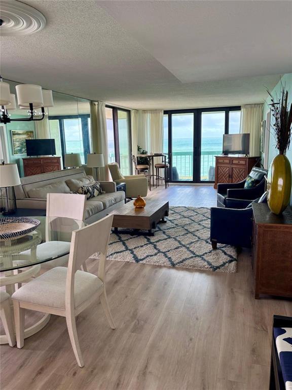 A living and dining area features light wood floors, a rug, and ocean views — 9940 S Ocean Drive # 501, Jensen Beach FL 34957, JENSEN BEACH, FL