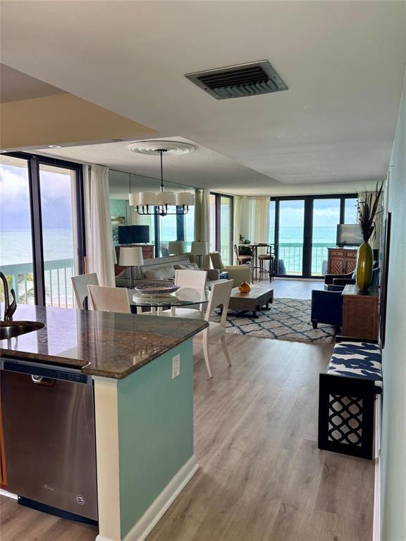 An open-concept living and dining area features ocean views, wood flooring, and a kitchen island — 9940 S Ocean Drive # 501, Jensen Beach FL 34957, JENSEN BEACH, FL