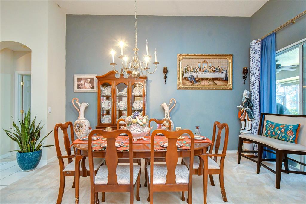 A formal dining room features a wooden table, chairs, a china cabinet, and blue walls — 2202 LONGMORE CIRCLE, VALRICO, FL
