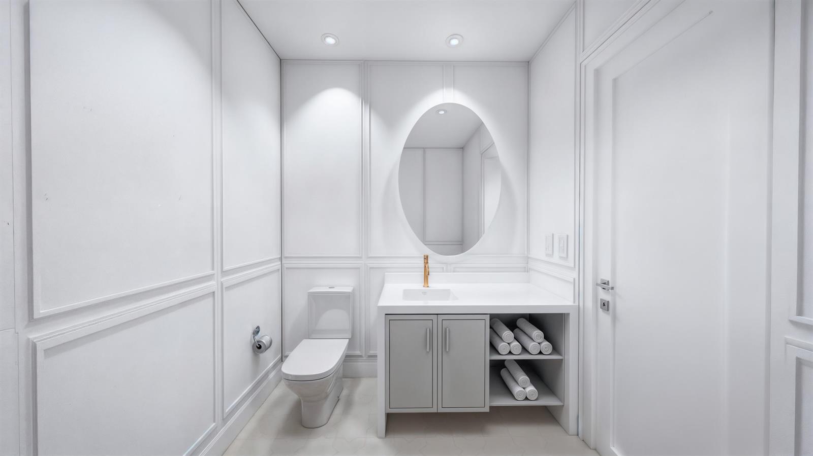 A modern white bathroom features a gray vanity, oval mirror, and wall molding — 1240 Aryana Way, Delray Beach FL 33445, DELRAY BEACH, FL
