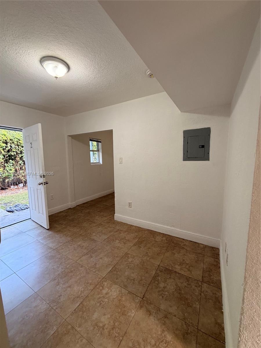 A room with tiled floors, a white door, and a wall-mounted electrical panel — 219 NW 10th St # 2, Miami FL 33136, MIAMI, FL