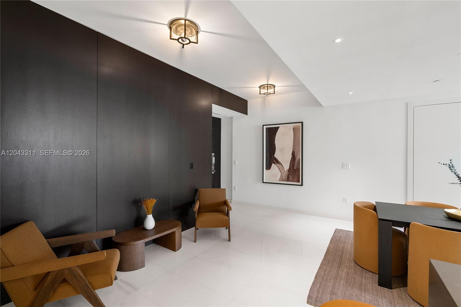 A modern dining area features a dark wood accent wall, white floors, and mustard-colored chairs — 300 Biscayne Boulevard Way # 4009W, Miami FL 33131, MIAMI, FL