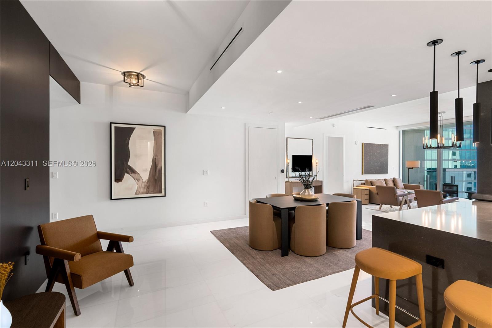 A modern open-concept living and dining area features white tile floors and brown furniture — 300 Biscayne Boulevard Way # 4009W, Miami FL 33131, MIAMI, FL