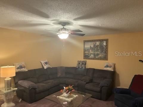 A living room features a large gray sectional sofa, a glass coffee table, and a ceiling fan — 532 BAHIA CIRCLE UNIT A, OCALA, FL