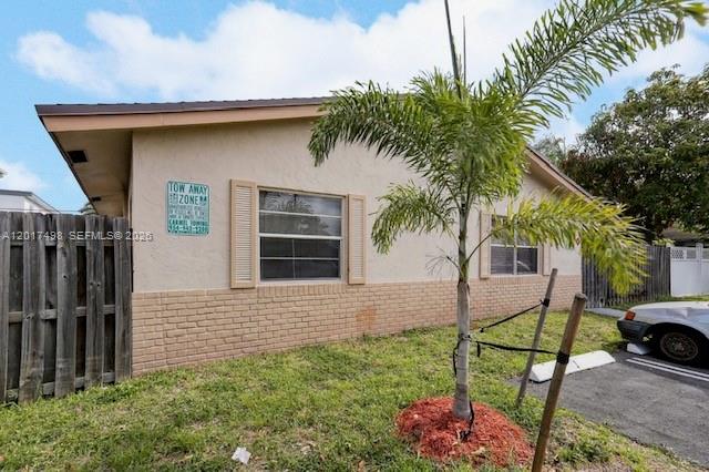 A single-story building with tan stucco walls, brick siding, and a small palm tree outside — 231 SW 8th Ct, Pompano Beach FL 33060, POMPANO BEACH, FL