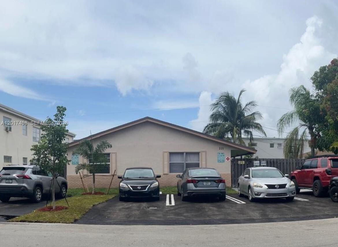A single-story house with a beige exterior and a paved parking area in front — 231 SW 8th Ct, Pompano Beach FL 33060, POMPANO BEACH, FL