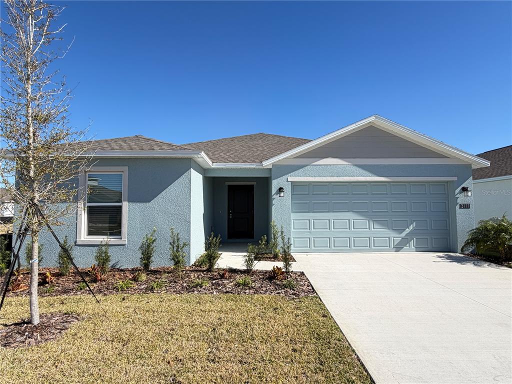 A light blue, single-story house features a two-car garage and a front walkway — 3111 TOTEM ROAD, EAGLE LAKE, FL