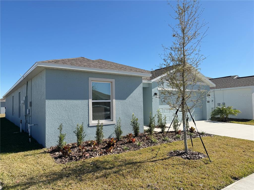 A light blue single-story house with a concrete driveway and a small front yard — 3111 TOTEM ROAD, EAGLE LAKE, FL