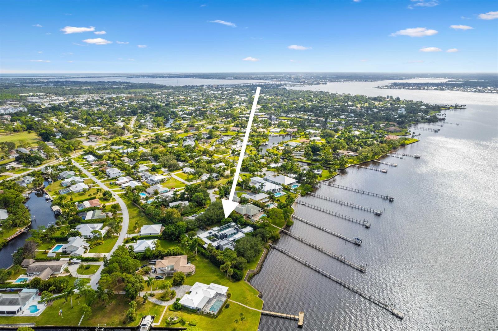 An aerial view shows a modern waterfront house with a pool and private dock — 1924 NW Shore Terrace, Stuart FL 34994, STUART, FL