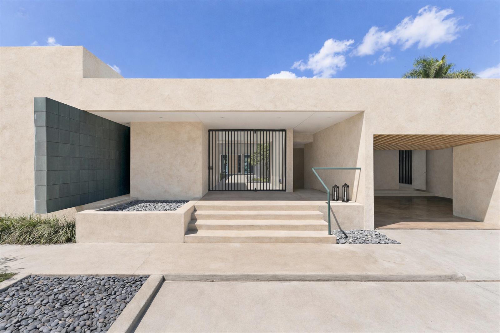 A modern house exterior features a beige stucco facade, stone steps, and a metal gate — 1924 NW Shore Terrace, Stuart FL 34994, STUART, FL