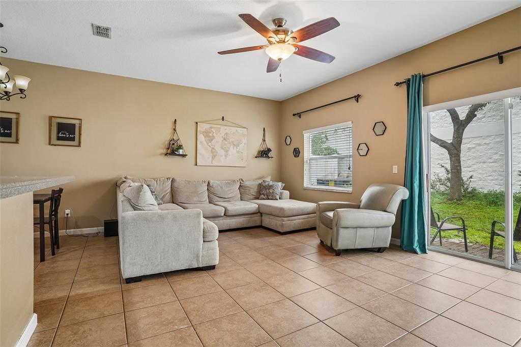 A living room features a beige sectional sofa, a matching armchair, and tile flooring — 1329 HERITAGE COMMONS DRIVE, WINTER SPRINGS, FL