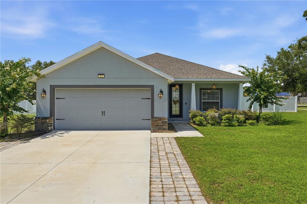 A single-story house with a two-car garage, stone accents, and a paved walkway — 362 LAKE STREET, UMATILLA, FL