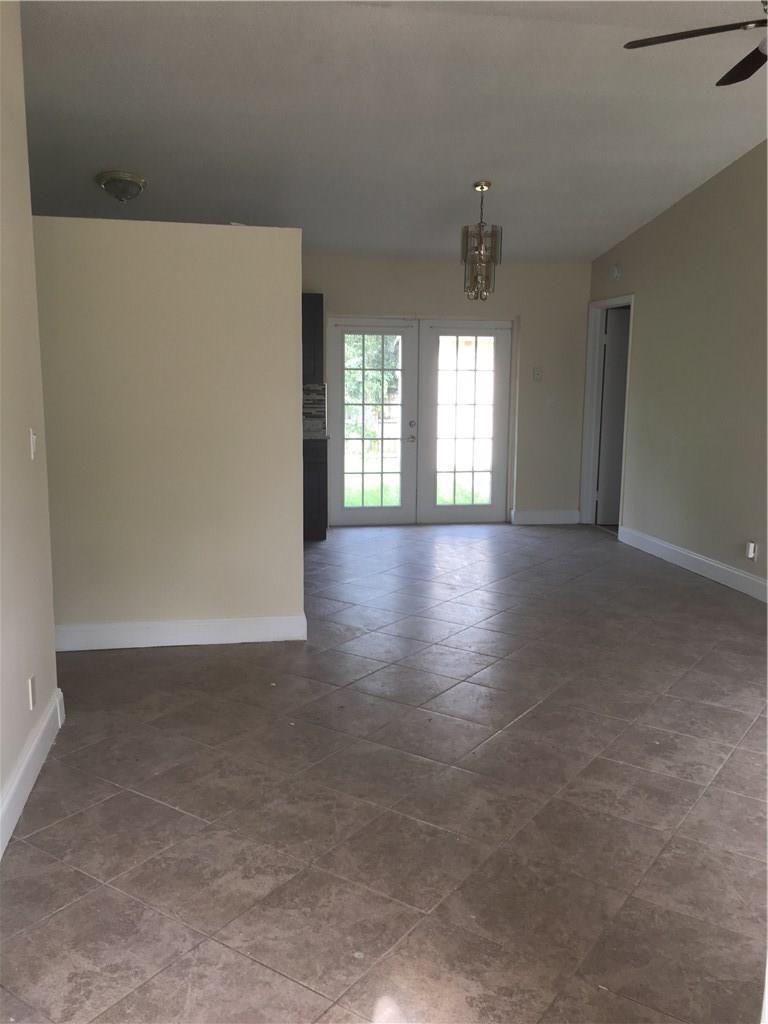 An interior room with beige walls, tile flooring, and French doors leading to the outdoors — 4231 SW 55th Avenue, Davie FL 33314, DAVIE, FL