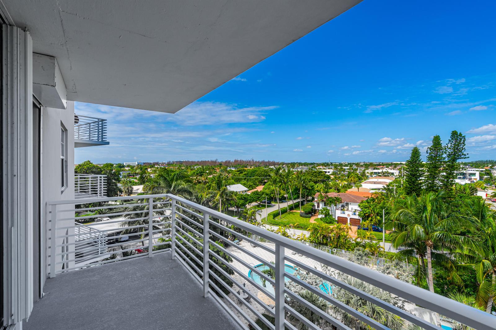A high-angle view from a white balcony overlooking a residential neighborhood with palm trees — 2851 S OCEAN Boulevard # 0086, Boca Raton FL 33432, BOCA RATON, FL