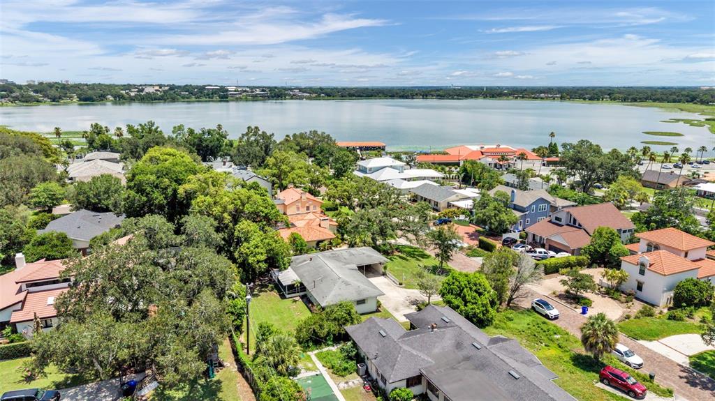 An aerial view shows a residential neighborhood with houses situated near a large lake — 2303 COVENTRY AVENUE, LAKELAND, FL