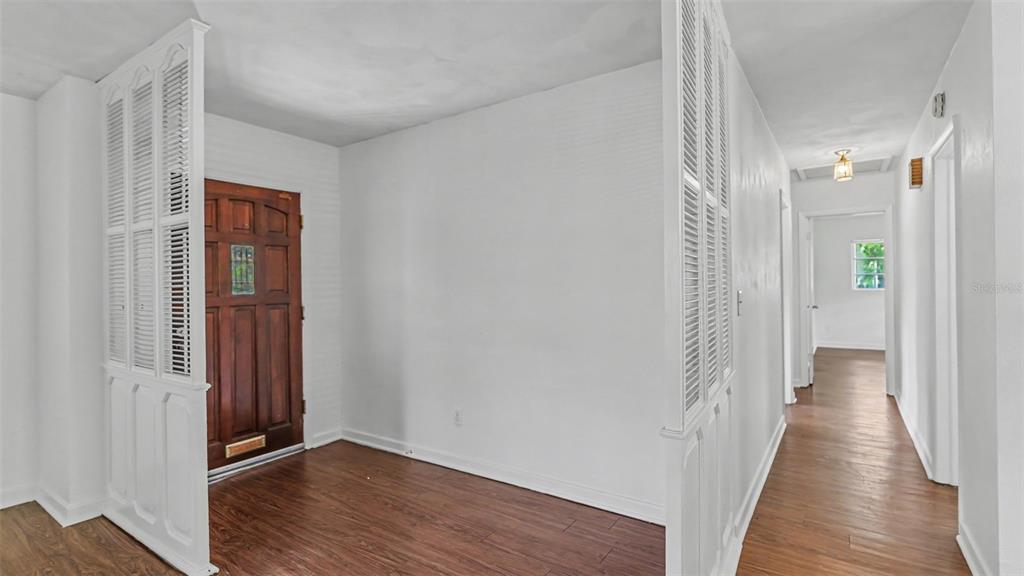 An entryway with wood-look flooring, white walls, and white louvered room dividers — 2303 COVENTRY AVENUE, LAKELAND, FL