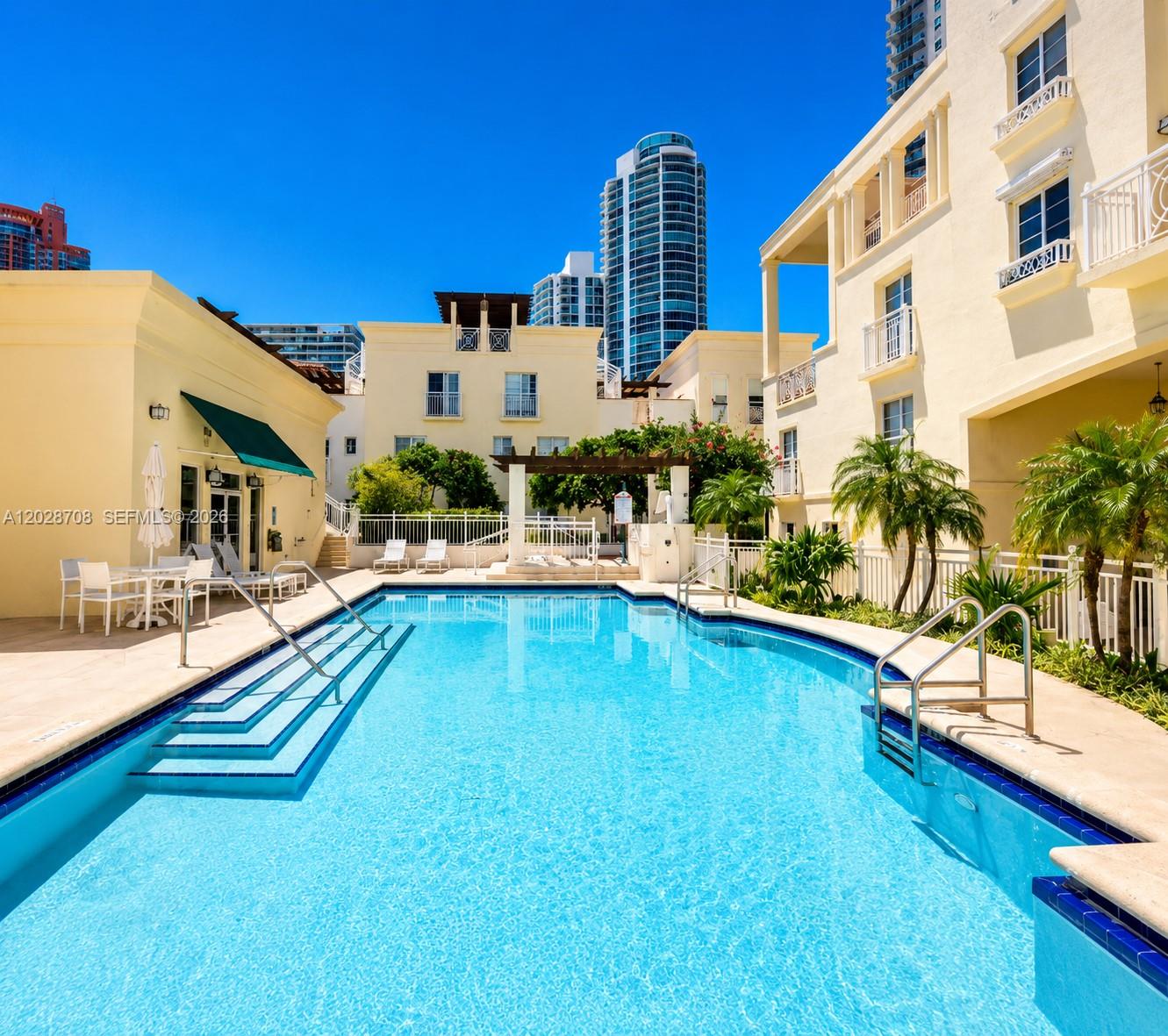 An outdoor swimming pool is surrounded by a patio, palm trees, and multi-story buildings — 145 Jefferson Ave # 415, Miami Beach FL 33139, MIAMI BEACH, FL