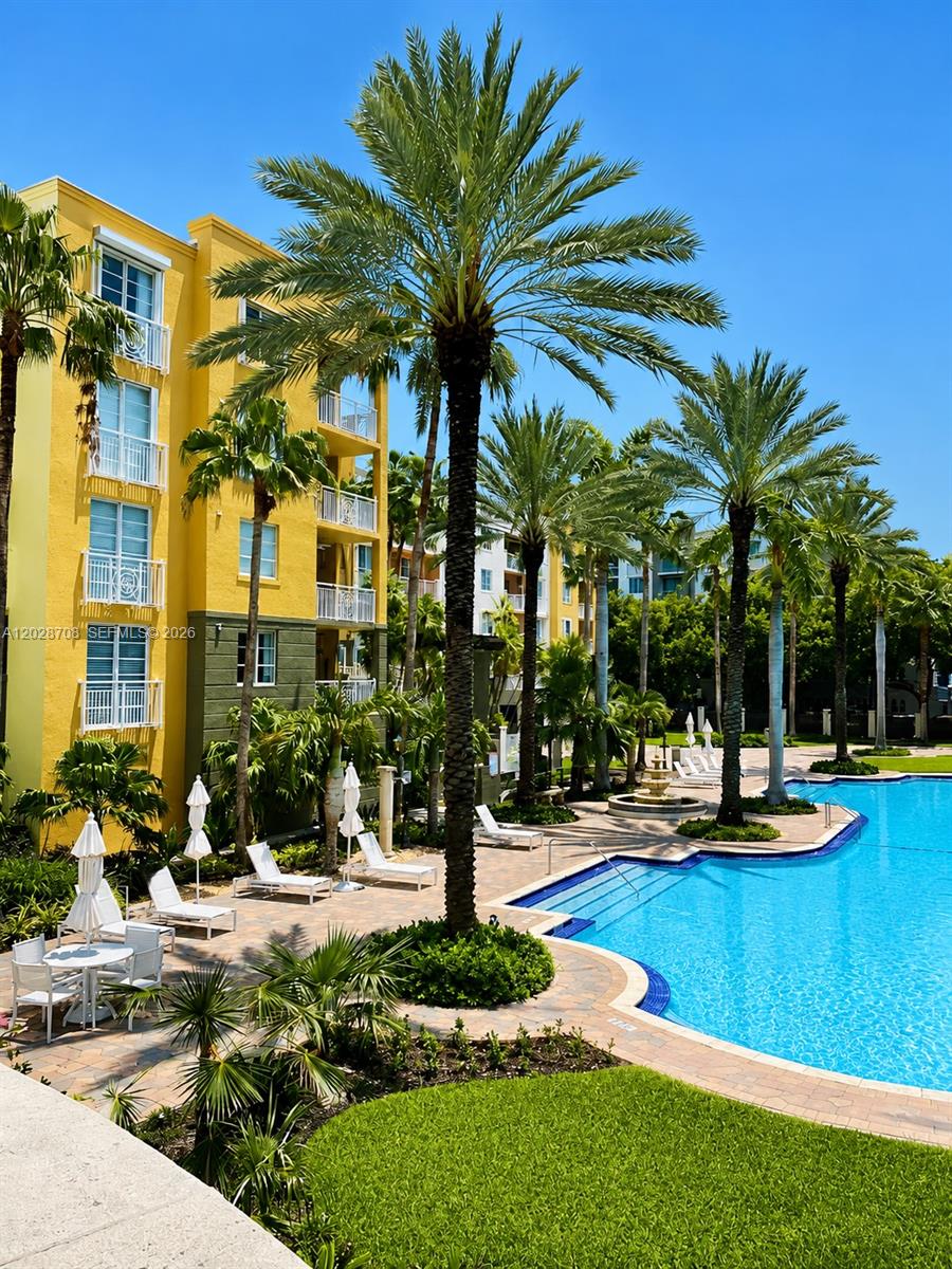A yellow multi-story apartment building overlooks a swimming pool surrounded by palm trees — 145 Jefferson Ave # 415, Miami Beach FL 33139, MIAMI BEACH, FL