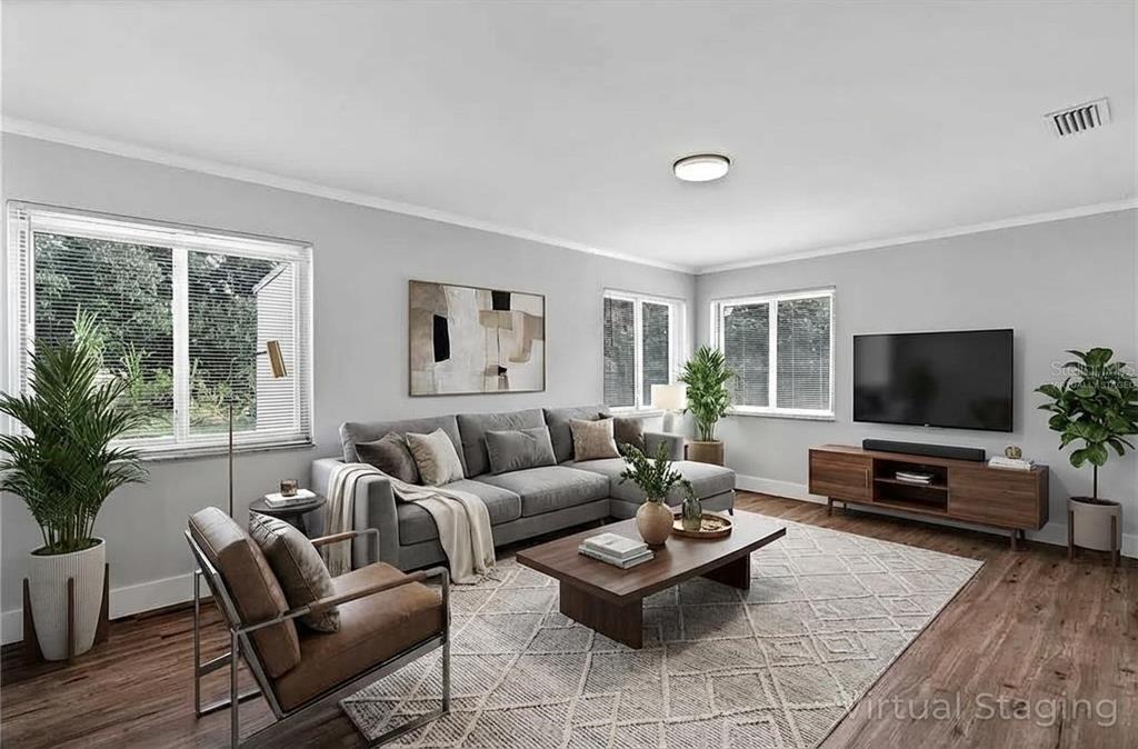 A living room with a gray sectional, leather chair, wood coffee table, and television — 4289 YUCATAN CIRCLE, PORT CHARLOTTE, FL