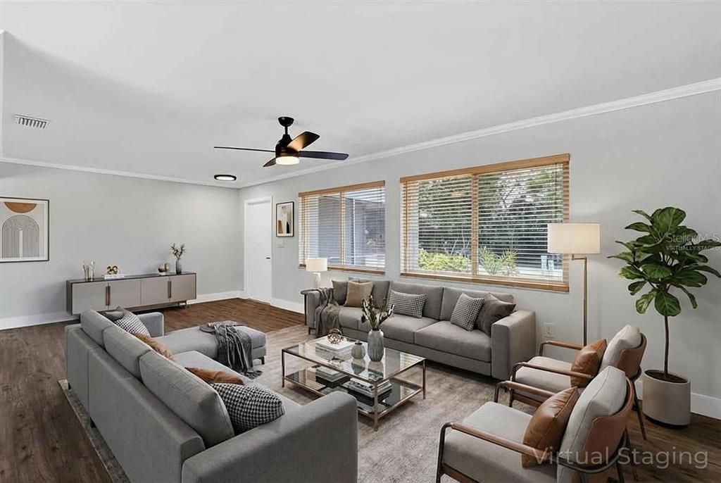 This living room features gray sofas, a glass coffee table, and wood-look flooring — 4289 YUCATAN CIRCLE, PORT CHARLOTTE, FL