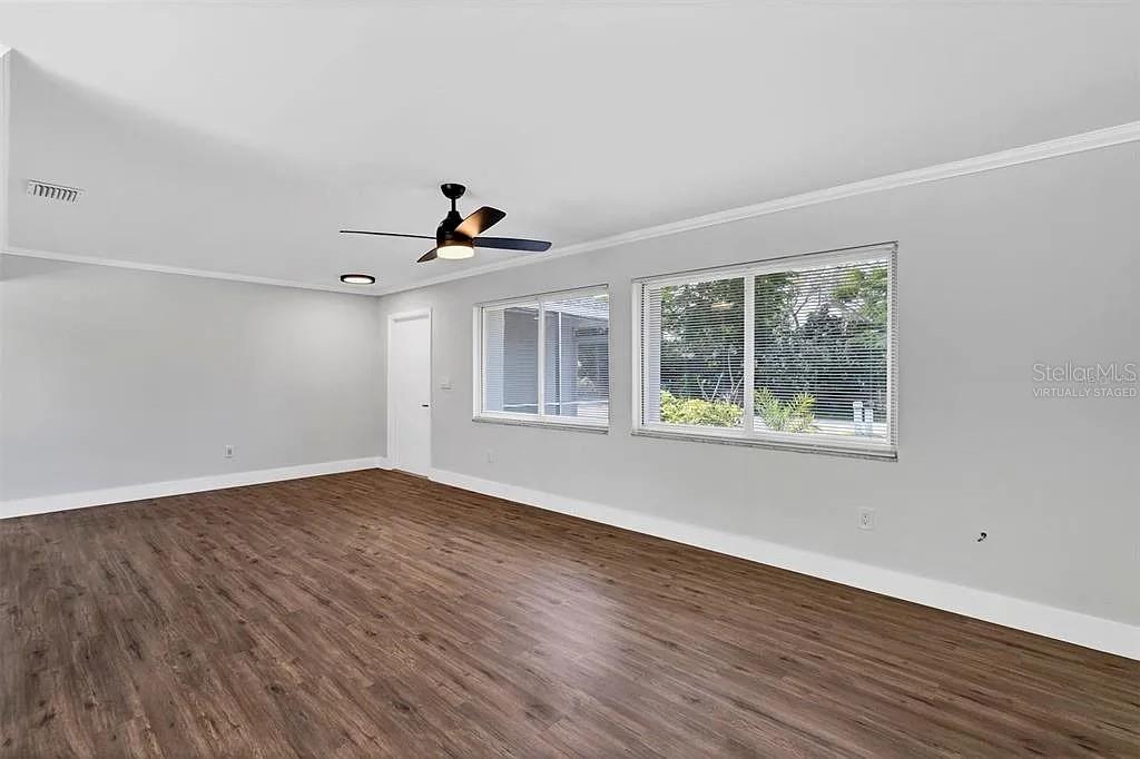 An empty room features light gray walls, dark wood-look flooring, and a ceiling fan — 4289 YUCATAN CIRCLE, PORT CHARLOTTE, FL