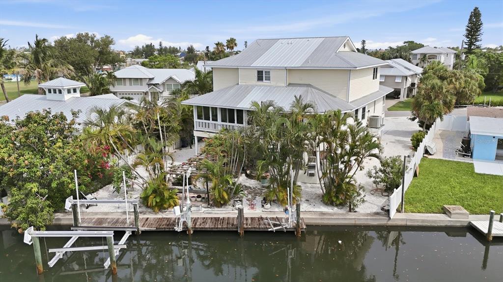 An aerial view of a yellow waterfront house with a metal roof and private dock — 505 59TH STREET, BRADENTON BEACH, FL