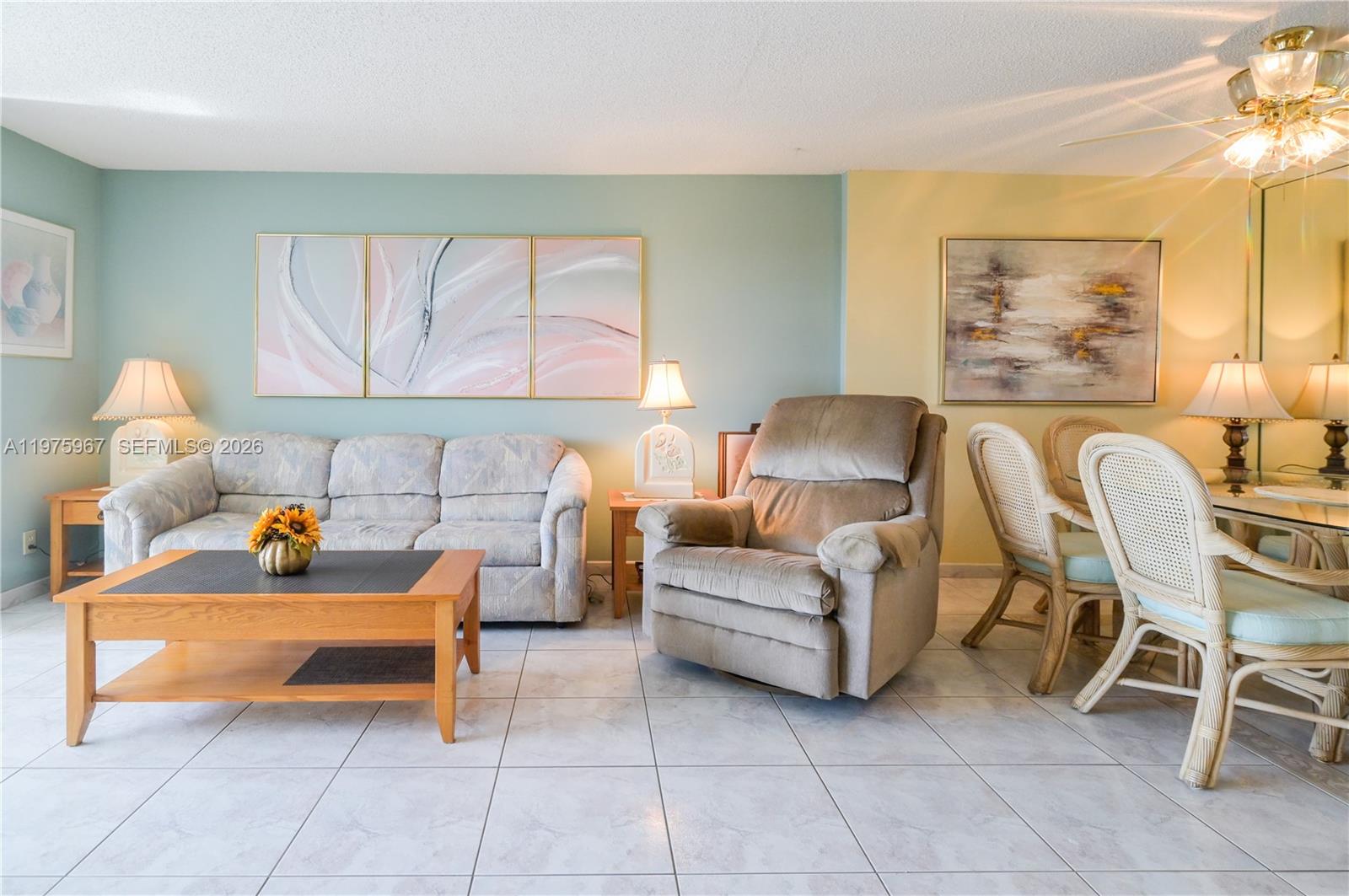 A living and dining area features tile floors, a sofa, a recliner, and wall art — 101 SE 3rd Ave # 401, Dania Beach FL 33004, DANIA BEACH, FL