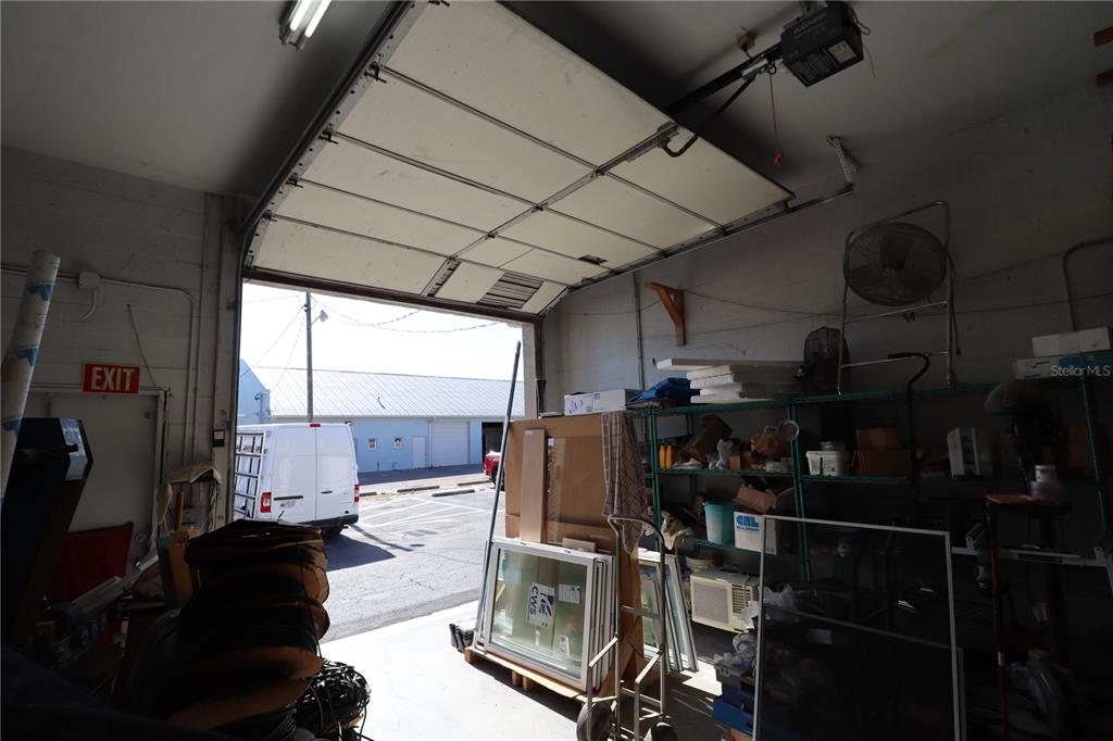 A view from inside a garage looking out through an open overhead door — 18350 PAULSON DRIVE UNIT D-1, PORT CHARLOTTE, FL