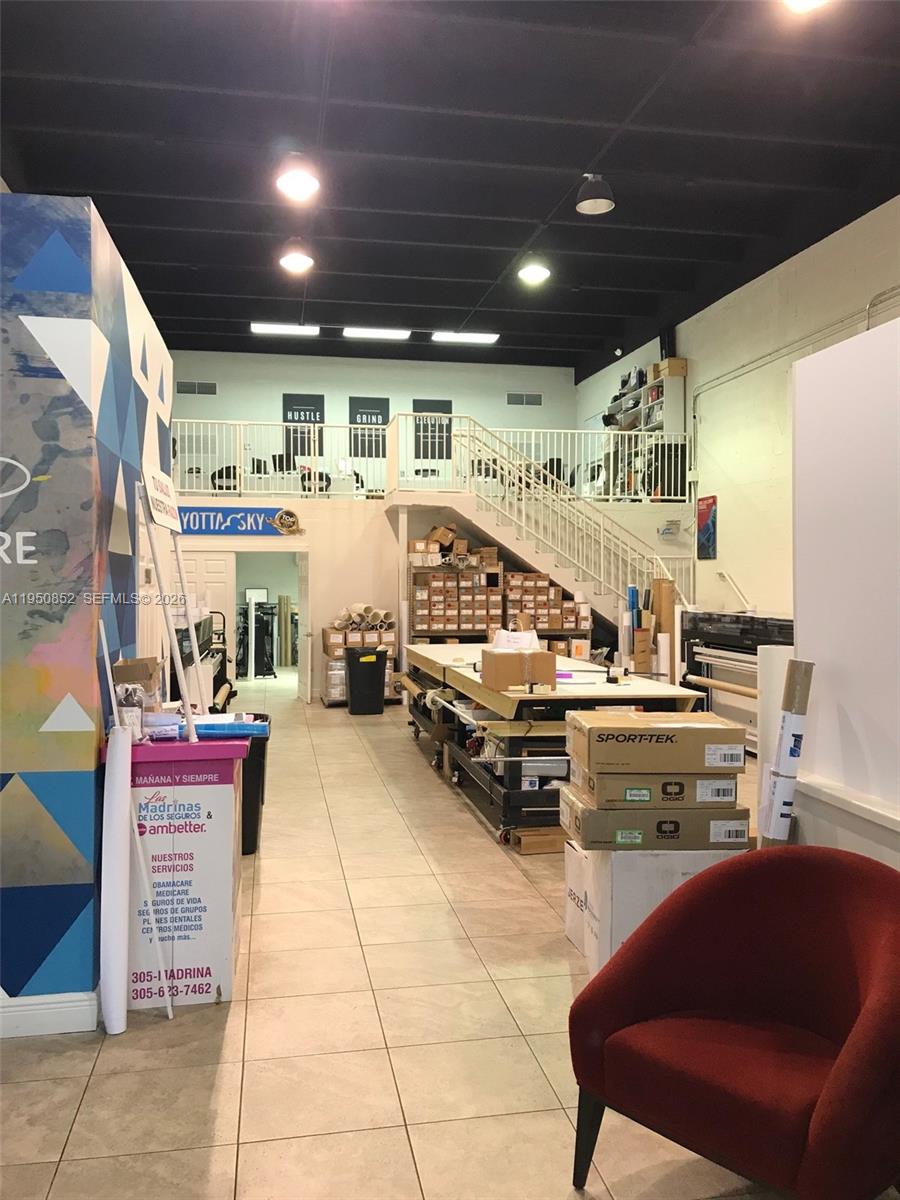 A commercial workspace features a mezzanine level, a central work table, and tiled flooring — 12300 SW 130th St # 7, Miami FL 33186, MIAMI, FL