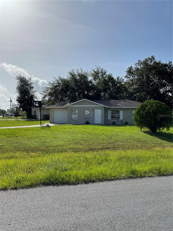A single-story house with a light-colored exterior and a large front lawn — 602 MCKINLEY COURT, KISSIMMEE, FL