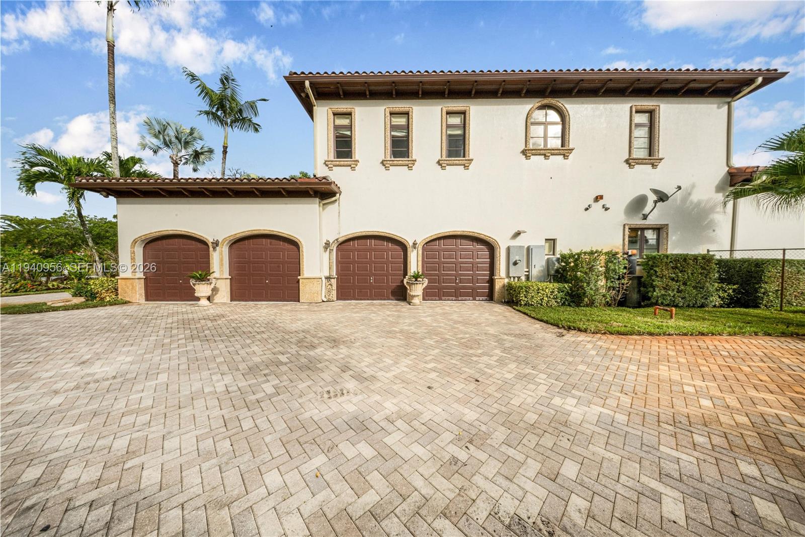 A two-story house exterior features four garage doors and a paved driveway — 7538 SW 64th St, Miami FL 33143, MIAMI, FL