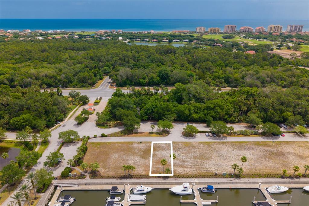 An aerial view shows a vacant lot highlighted by a white rectangle near a marina — 106 HARBOR VILLAGE POINT S, PALM COAST, FL