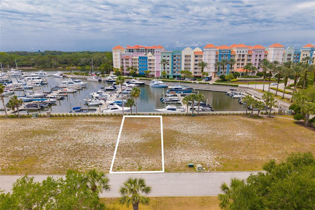An aerial view shows a vacant rectangular lot situated in front of a marina — 106 HARBOR VILLAGE POINT S, PALM COAST, FL