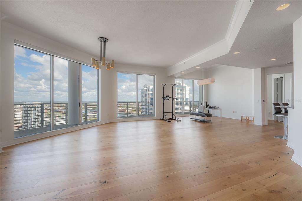 An open-concept living area features light wood flooring, floor-to-ceiling windows, and a fitness pull-up station — 449 S 12TH STREET UNIT 2701, TAMPA, FL