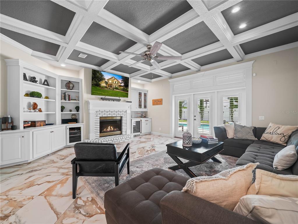 A living room features a coffered ceiling, a fireplace with built-in shelving, and tile flooring — 6556 CRESCENT LAKE DRIVE, LAKELAND, FL
