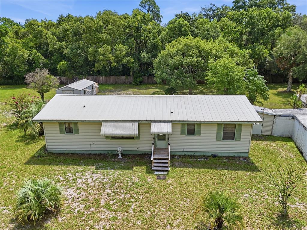 An aerial view of a single-story house with a metal roof and light-colored siding — 44144 DOLLYS WAY, DELAND, FL