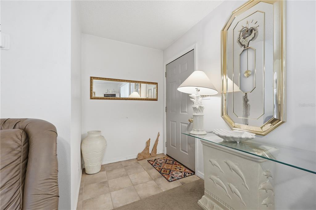 An entryway features tile flooring, a console table with a lamp, and wall-mounted mirrors — 44144 DOLLYS WAY, DELAND, FL