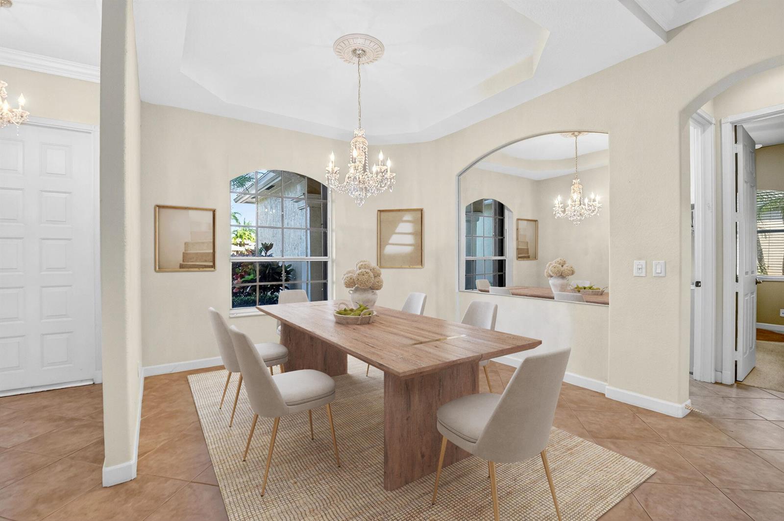 A dining room features a wooden table, six chairs, a crystal chandelier, and a large mirror — 9566 Lantern Bay Circle, West Palm Beach FL 33411, WEST PALM BEACH, FL