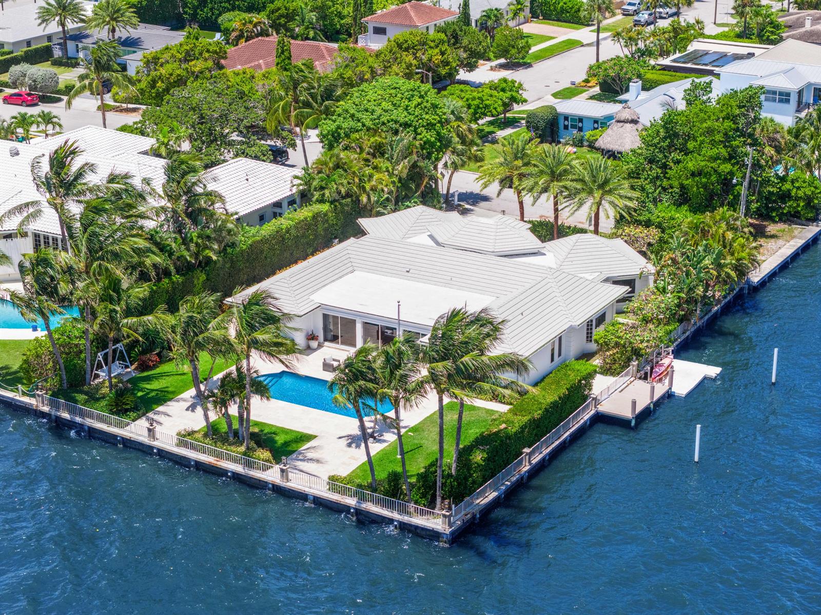 An aerial view shows a white house with a pool and dock on a canal — 2204 Notre Dame Drive, FL 33460, FL