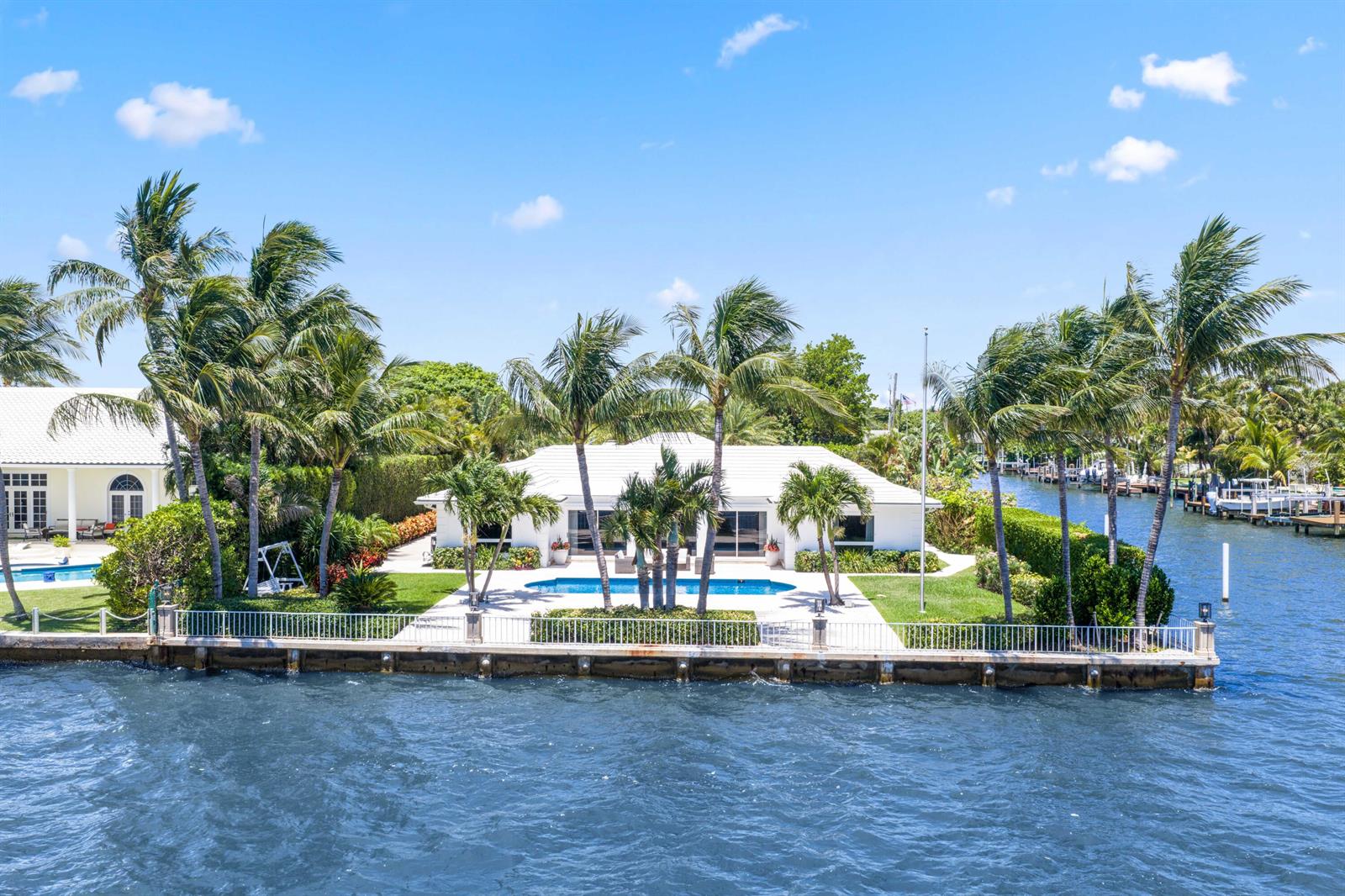 An aerial view of a waterfront house with a pool, palm trees, and a seawall — 2204 Notre Dame Drive, FL 33460, FL