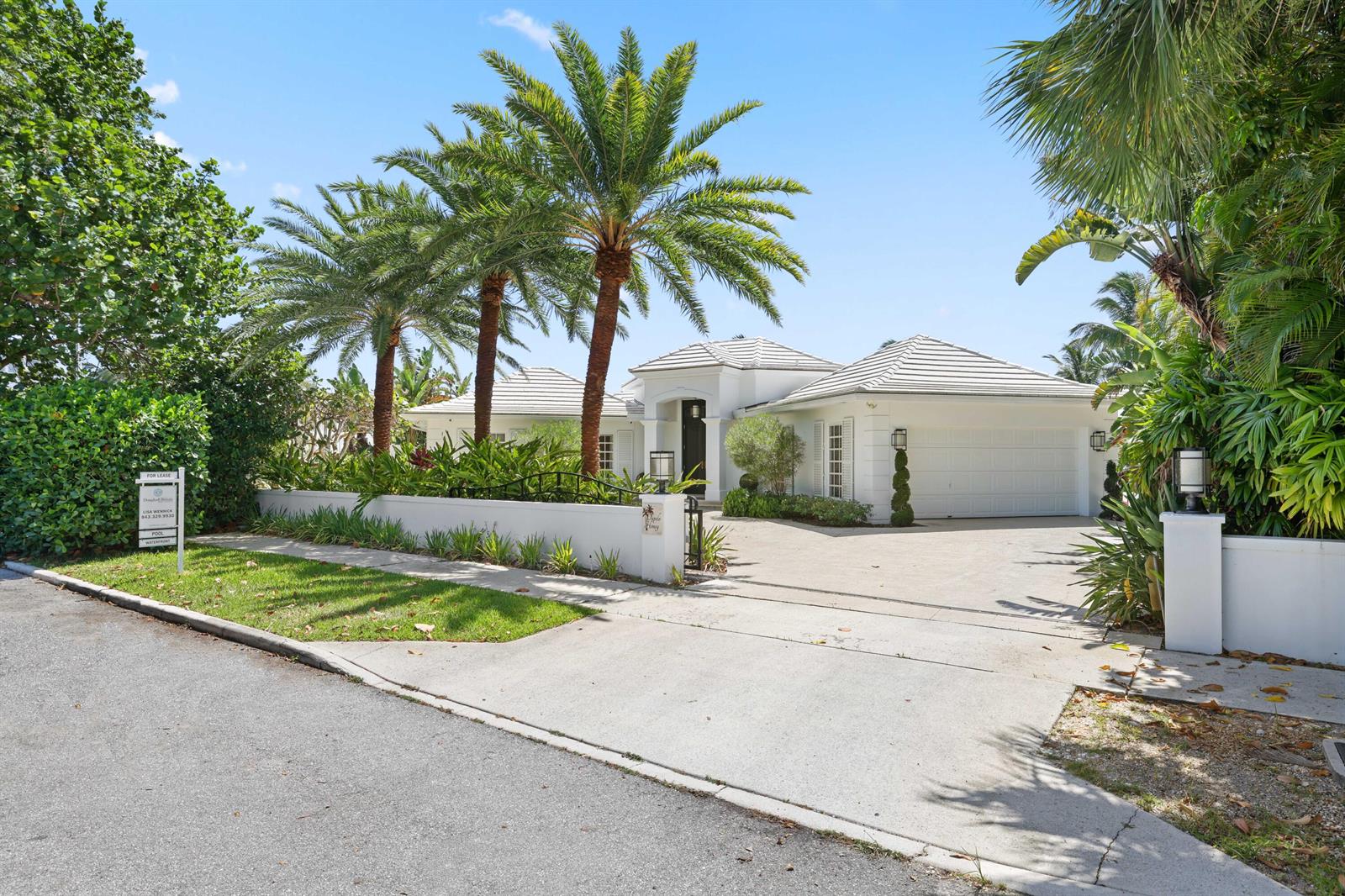 A white single-story house with a tiled roof, palm trees, and a concrete driveway — 2204 Notre Dame Drive, FL 33460, FL