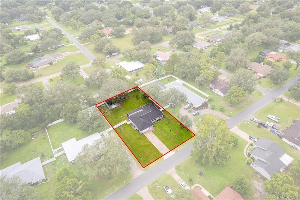 An aerial view shows a single-story house with a dark roof on a grassy lot — 3218 S ROSE AVENUE, INVERNESS, FL