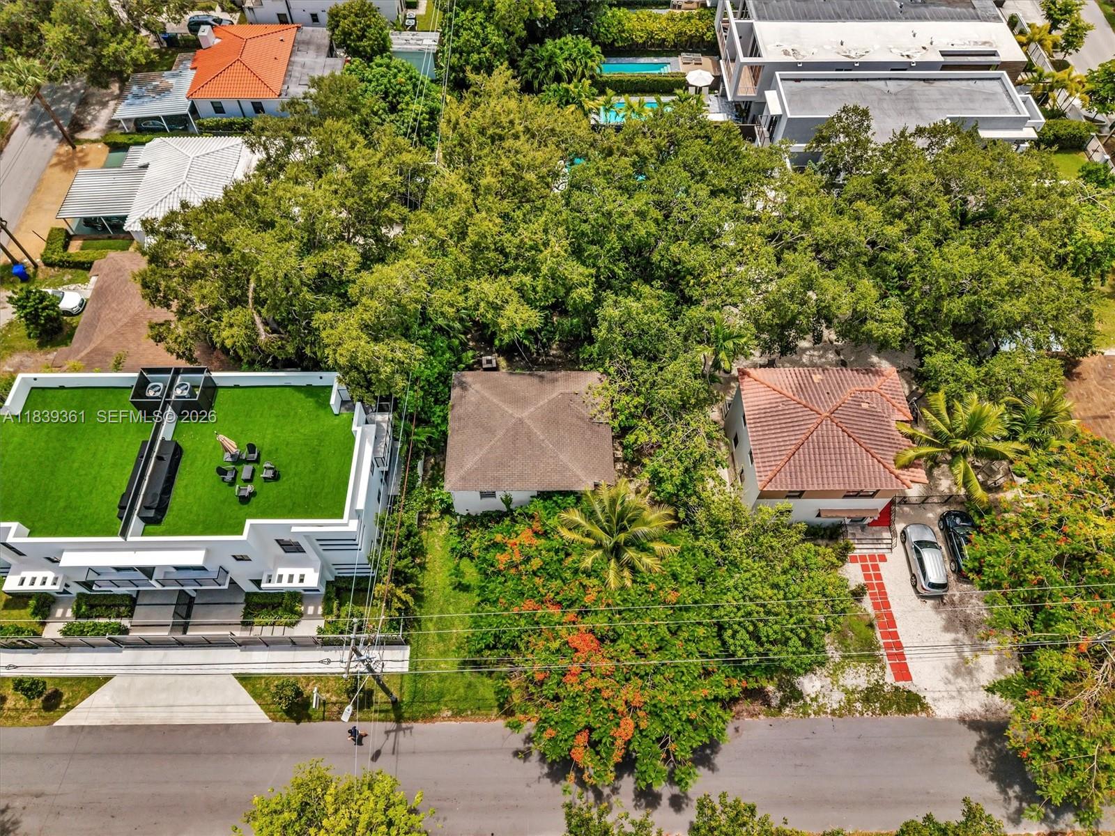 An aerial view shows three houses with varying roof styles and a green rooftop terrace — 3210 E Elizabeth St, Miami FL 33133, MIAMI, FL