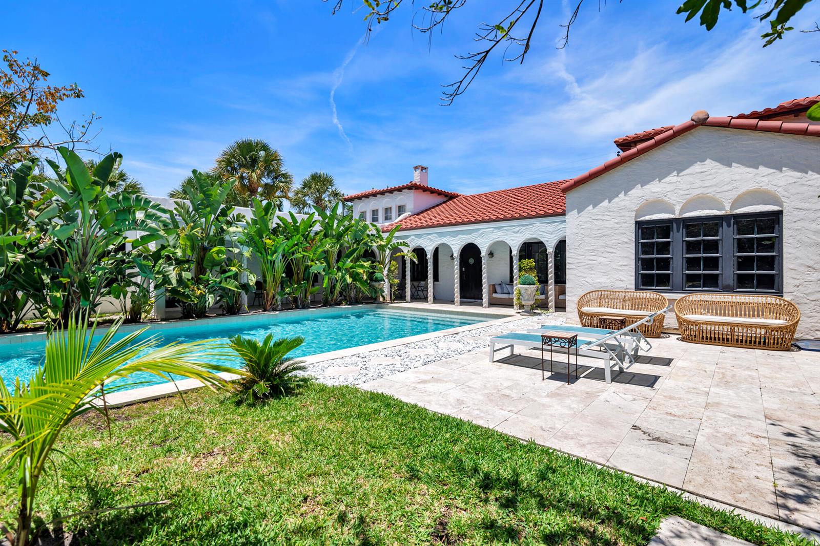 A swimming pool sits beside a white stucco house with a red tile roof — 333 Murray Road, West Palm Beach FL 33405, WEST PALM BEACH, FL